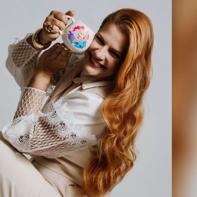 Fab&iacute;ola Pereira Morais segurando uma caneca pintada &agrave; m&atilde;o